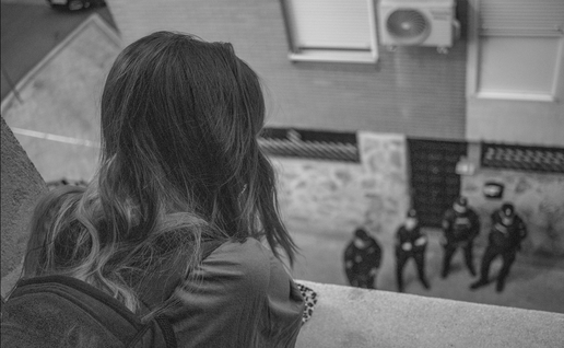 Girl on a balcony looking down at police offices