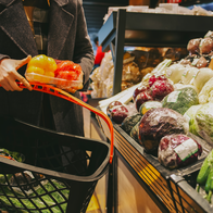 Woman holding a shopping basket holding a vegetable