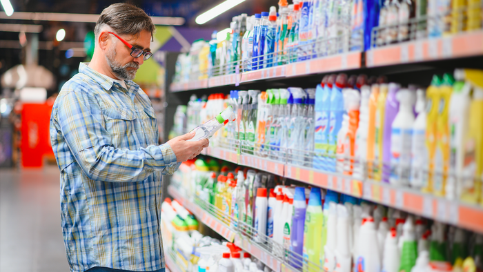 Man in a supermarket looking at cleaning products