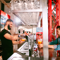 A man in a bar serving a beer