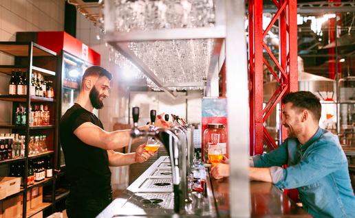 A man in a bar serving a beer