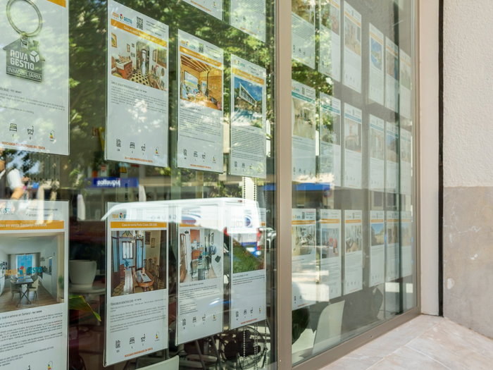 Spanish estate agency window displaying rental and property listings amid housing uncertainty