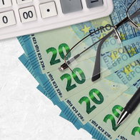 Euro banknotes, calculator and glasses illustrating pension repayments after Spain Social Security error