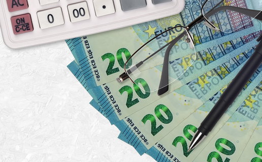 Euro banknotes, calculator and glasses illustrating pension repayments after Spain Social Security error