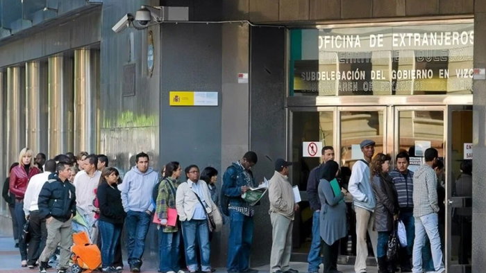 People queue outside a Spanish immigration office as demand rises for appointments under the new residency scheme
