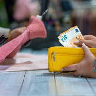 Customer paying with euro cash at a shop counter