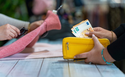 Customer paying with euro cash at a shop counter