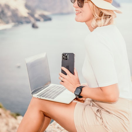 Digital nomad working remotely on a laptop by the sea in Spain