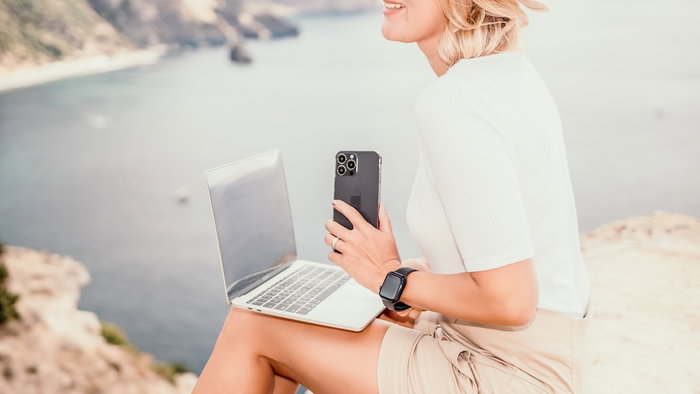 Digital nomad working remotely on a laptop by the sea in Spain