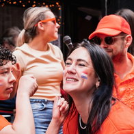 People dressed in orange with flags celebrating Dutch Kings Day
