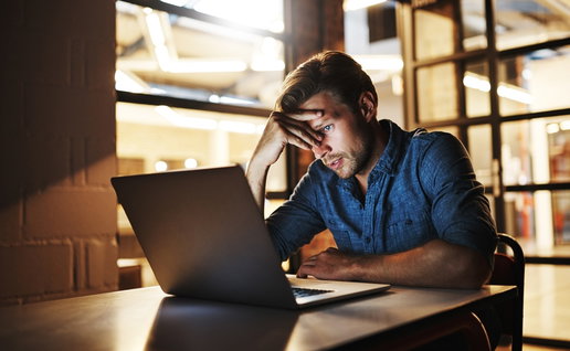Man looking worried at laptop after receiving suspicious scam email in Spain