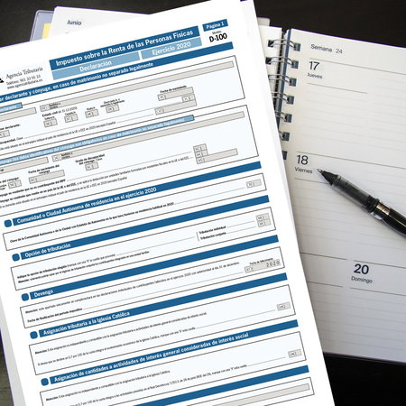 Spanish income tax form (Declaración de la Renta) next to an open planner and pen