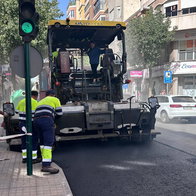 Workers resurfacing road with asphalt in Elche urban area during paving works