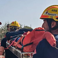 Firefighters carrying injured man on stretcher along rural path near Agost Alicante