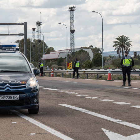 Traffic police stopping cars at a checkpoint on a Spanish road at night