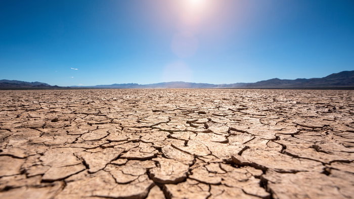 Cracked dry land under intense heat representing uninhabitable future climate on Earth