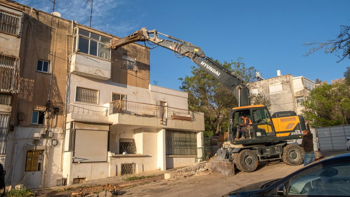 Bulldozer demolishing residential structures in a Madrid informal settlement