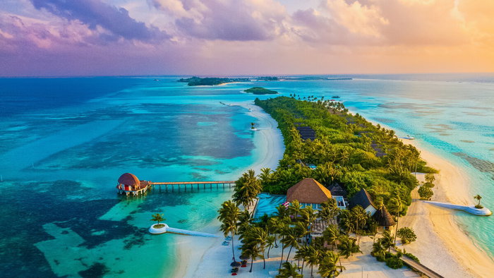 Aerial view of Maldives islands surrounded by turquoise water showing low-lying coastline