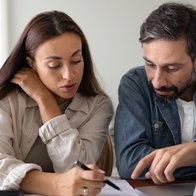 People reviewing mortgage documents with calculator amid changing interest rate expectations in Spain