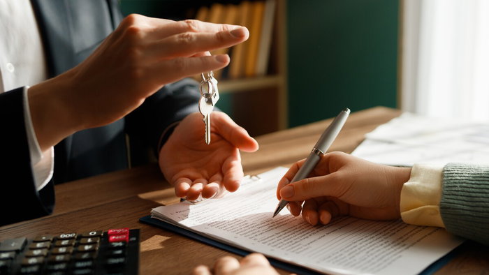 Woman reviewing mortgage documents and financial calculations at home in Spain