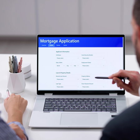 Person filling out mortgage application form with documents and calculator