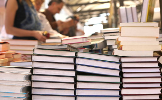 Visitors browsing book stalls at Elche book fair along Paseo de la Estación