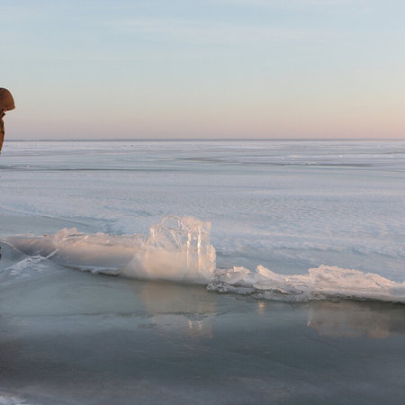 Frozen mountain lake in Pyrenees with unstable ice during spring
