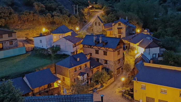 Aerial view of San Facundo, a small mountain village in León, Spain, with illuminated houses at dusk