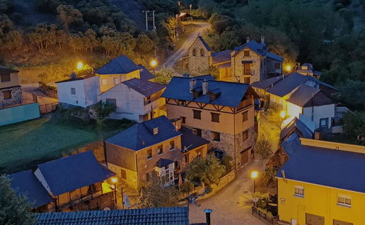 Aerial view of San Facundo, a small mountain village in León, Spain, with illuminated houses at dusk