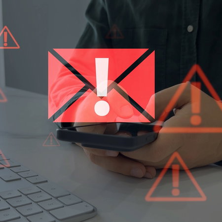 Person checking a mobile phone with warning symbols during a fake Social Security scam alert in Spain