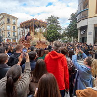 Semana Santa procession in Spain with large crowd watching religious parade in city street