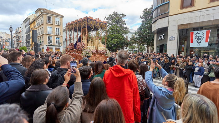 Semana Santa procession in Spain with large crowd watching religious parade in city street