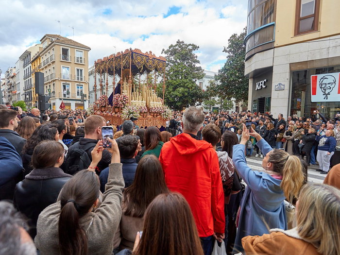 Semana Santa procession in Spain with large crowd watching religious parade in city street