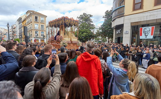 Semana Santa procession in Spain with large crowd watching religious parade in city street