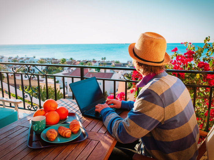 Man working at computer on Spanish balcony