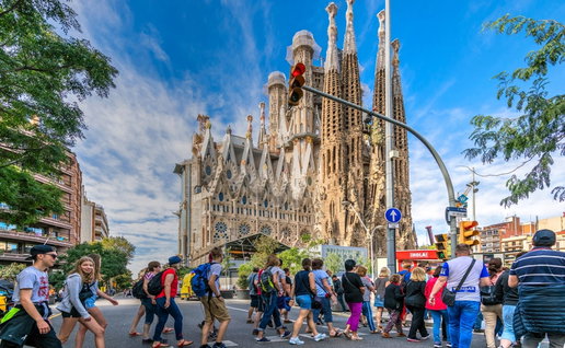 Tourists crossing the street to go to visit the Sagrada Familia basilica church