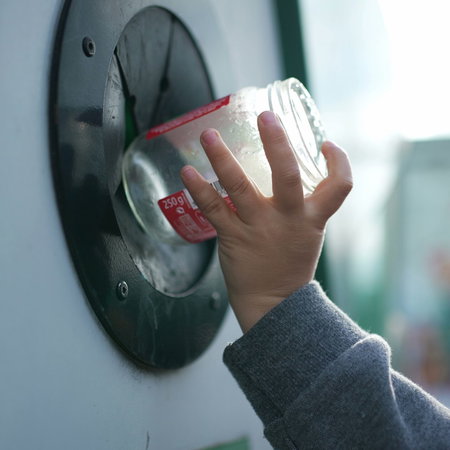 Boy recycling a glass jar