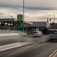 Cars driving passed a petrol station
