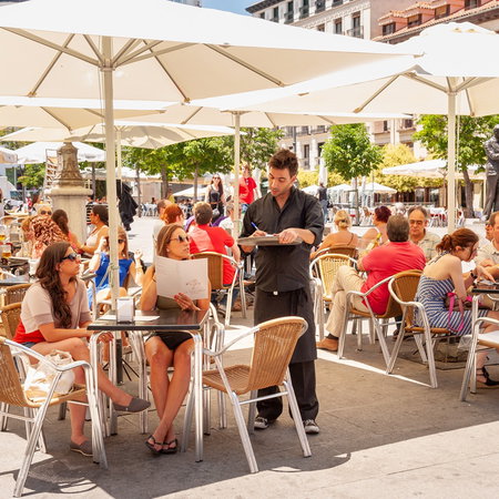 Busy restaurant terrace in Spain as bars face fines for unpaid overtime and long staff hours