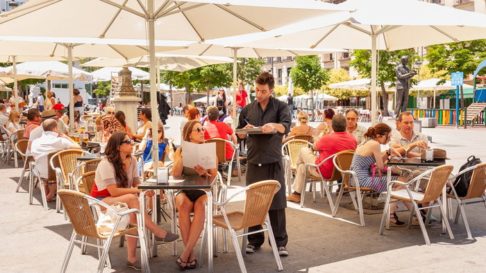 Busy restaurant terrace in Spain as bars face fines for unpaid overtime and long staff hours