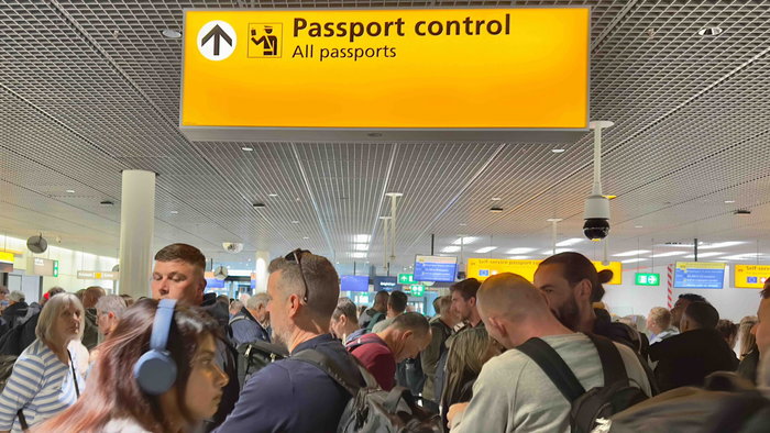 Travellers queue at airport passport control as Europe introduces the new EES digital border system