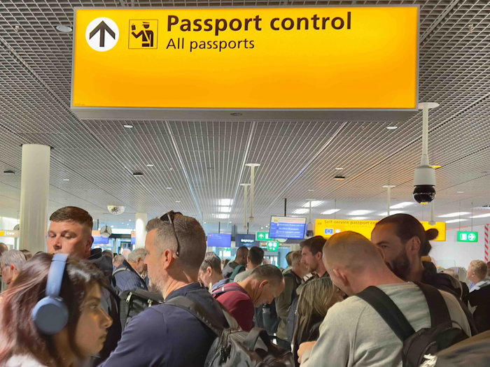 Travellers queue at airport passport control as Europe introduces the new EES digital border system