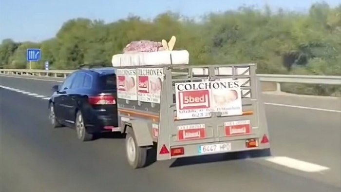 woman on top of mattresses on a trailer