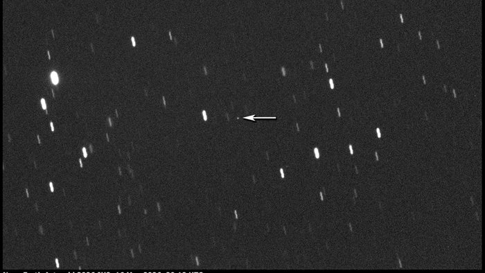 Telescope image showing near Earth asteroid 2026 JH2 approaching Earth, with an arrow marking the object against a star filled night sky.