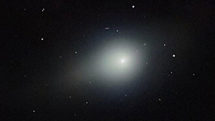 Comet 3I/ATLAS appears as a glowing object in deep space surrounded by distant stars.