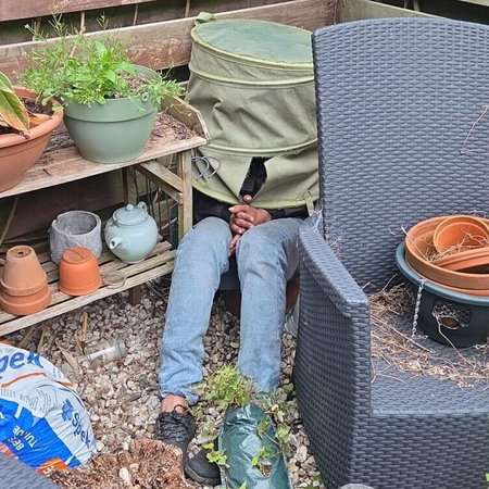 Man hiding under laundry basket