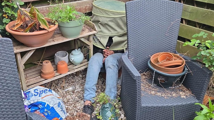 Man hiding under laundry basket