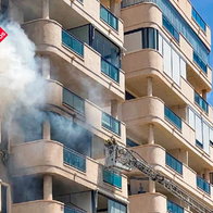 Firefighters working outside a residential building after a fire in Villajoyosa