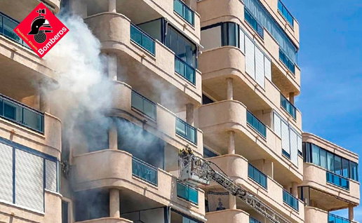 Firefighters working outside a residential building after a fire in Villajoyosa