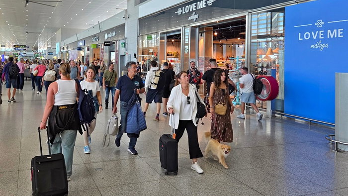 Passengers walk through a busy airport terminal as airlines warn of possible summer flight disruptions linked to fuel supply concerns.